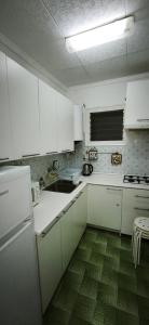 a kitchen with white cabinets and a green floor at Playa de Sant Adrià de Besòs in Sant Adria de Besos