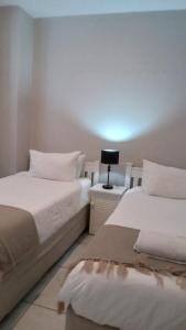 twee bedden naast elkaar in een slaapkamer bij Westville passion place in Durban