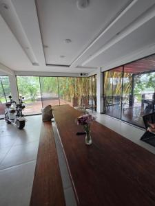 een woonkamer met een lange houten tafel en glazen wanden bij Eletrica solar in Coxim