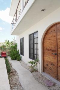 a house with a wooden door and a walkway at Casa Calandria in Chicxulub