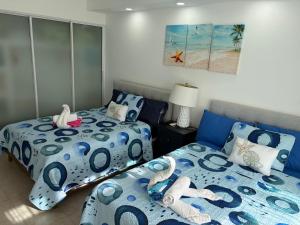1 Schlafzimmer mit 2 Einzelbetten mit blauer und weißer Bettwäsche in der Unterkunft Oasis by the beach Retiro 1 in Punta Cana + 26 Fotos