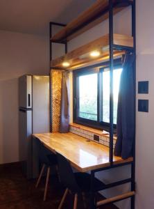 a kitchen with a wooden table and a window at Libra Eco-Adventure Hostel in El Pescadero +26 photos