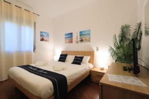 een slaapkamer met een groot bed en een potplant bij Casa vacanze Ciachea Home - con BBQ , Parcheggio gratuito , A 10 min Da Palermo & Aeroporto in Carini