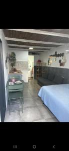 een slaapkamer met een bed, een tafel en een bank bij Bujanvilla in Tarifa