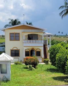 una grande casa gialla con un balcone sopra di AOS Rentals a Vreed en Hoop