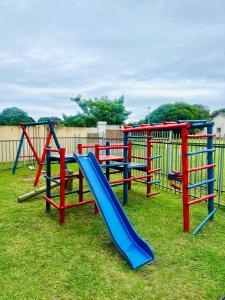 een speeltuin met een glijbaan in het gras bij 12th on The Bay in Richards Bay