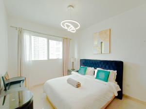 a bedroom with a large bed with a blue headboard at Exclusive Sea-View 2BR Apartment with Fireworks View in New-year eve in Abu Dhabi