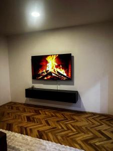 a tv on a wall with a fire in it at Ember Residence Spacious 2BR Apartment near Eternal Flame in Sarajevo