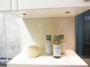 three bottles of vinegar and a shell on a shelf at Ember Residence Spacious 2BR Apartment near Eternal Flame in Sarajevo