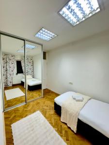 a bedroom with two beds and a mirror and skylights at Ember Residence Spacious 2BR Apartment near Eternal Flame in Sarajevo