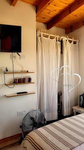 a bedroom with a bed and a flat screen tv at Brisas De Las Sierras in Villa Ciudad Parque