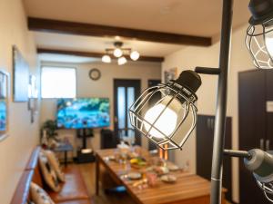 een lamp in een woonkamer met een tafel bij ゲストハウス海と石 in Takamatsu