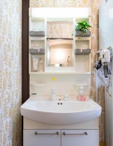een badkamer met een wastafel en een spiegel bij ゲストハウス海と石 in Takamatsu +54 foto's