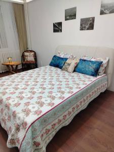 een slaapkamer met een groot bed met blauwe kussens bij Sava centar apartman in Belgrado