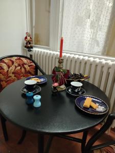 een tafel met een kaars en borden eten erop bij Sava centar apartman in Belgrado