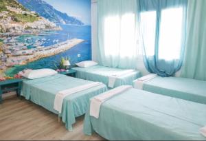 a room with three beds and a painting of a beach at Can Pau Llanca Sf Parascheva in Llança +16 photos