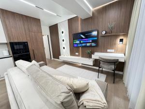 a living room with a white couch and a tv at RentNow Apartments Luxury Apartment with Balcony and Parking in Chişinău