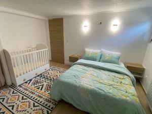 una camera con un grande letto e una culla di Cozy ground floor apartment a Xonrupt-Longemer
