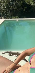 een persoon in een stoel naast een zwembad bij Loft El Taller - Rústico, elegante, acogedor in Yerba Buena +14 foto's