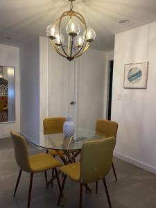 una sala da pranzo con tavolo in vetro e sedie gialle di - Touristic Area 1 BR Avenida Revolucion a Tijuana