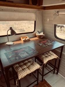 une table à l'arrière d'un train avec deux chaises dans l'établissement Cabaña casa rodante, à Tongoy 4 autres photos