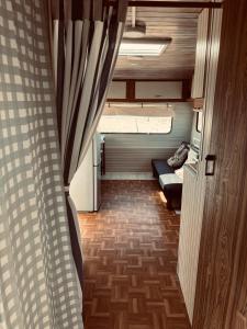 une petite chambre avec un canapé et un rideau dans l'établissement Cabaña casa rodante, à Tongoy