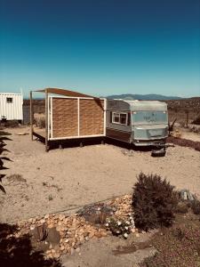 un wagon garé dans un champ avec une clôture dans l'établissement Cabaña casa rodante, à Tongoy