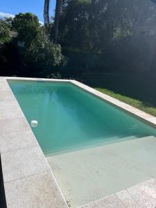 a swimming pool with blue water in a yard at Loft El Taller - Rústico, elegante, acogedor in Yerba Buena