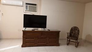 维多利亚城Residencia completa 2 recamaras para 4 con cochera的木质梳妆台上的平面电视,配有椅子