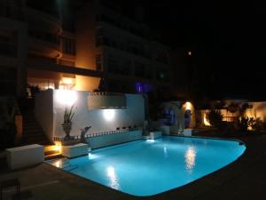 a swimming pool lit up at night at Oceanfront Rosarito Balcony Beach & Amazing Sunsets in Rosarito Beach