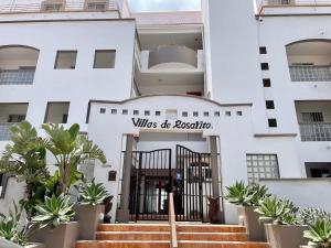 a white building with a gate in front of it at Oceanfront Rosarito Balcony Beach & Amazing Sunsets in Rosarito Beach +20 photos