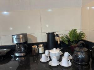 a kitchen counter with a coffee maker and coffee cups at Tríade Chalé da Canastra 2 in São Roque de Minas