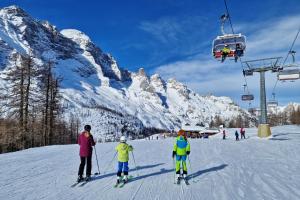 eine Gruppe von Menschen, die einen Skilift im Schnee fahren in der Unterkunft Residence Panorama in Val di Zoldo