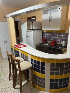 une cuisine avec un comptoir carrelé jaune et bleu dans l'établissement Residencial Brila Mar, à Capão da Canoa