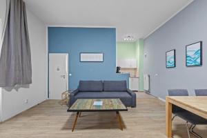 un salon avec un canapé bleu et une table dans l'établissement Apartment Uthman Berlin-Neukölln, à Berlin