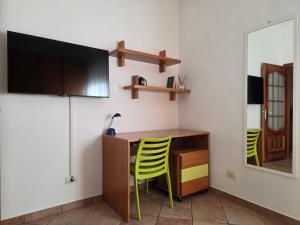 eine Küche mit einem Schreibtisch und 2 gelben Stühlen in der Unterkunft Casa Valle in Rozzano