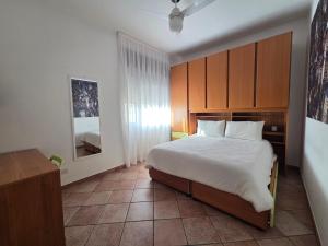 Schlafzimmer mit einem großen weißen Bett und Holzschränken in der Unterkunft Casa Valle in Rozzano