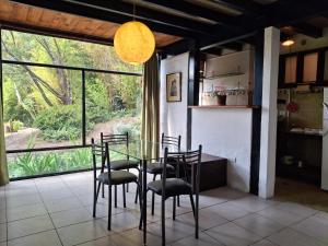 een eetkamer met een glazen tafel en stoelen bij Casa del Aguacate Cumbaya - Tumbaco in Cumbayá