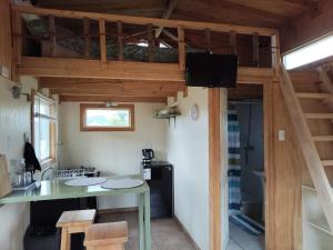 a room with a kitchen and a loft at La petite cabane de Putemun in Castro