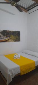 een slaapkamer met een bed met twee handdoeken erop bij Casa Hostel Necoclí Playa Brisa y Mar in Necoclí