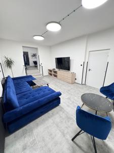 een woonkamer met een blauwe bank en een tafel bij Accommodation for large groups Teplice in Teplice