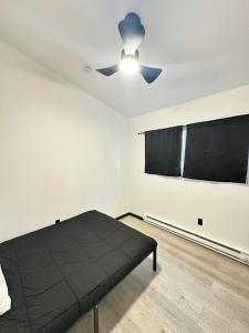 - une chambre avec un lit noir et un ventilateur de plafond dans l'établissement Bears Den Cabin #3, à Houston 4 autres photos