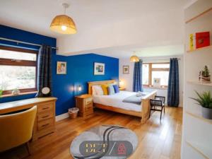 une chambre avec un lit et un mur bleu dans l'établissement Carden Hill House - 4 Bedrooms - Sleeps 9 - Free Parking - Games Room - Ideal for Contractors, Families and Large Groups, à Brighton et Hove