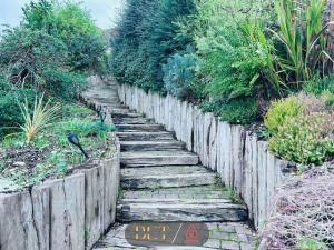 un chemin de pierre dans un jardin avec une clôture en bois dans l'établissement Carden Hill House - 4 Bedrooms - Sleeps 9 - Free Parking - Games Room - Ideal for Contractors, Families and Large Groups, à Brighton et Hove