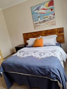 une chambre avec un lit recouvert d'une couette bleue et un parapluie dans l'établissement Valley Rest, à Mbabane