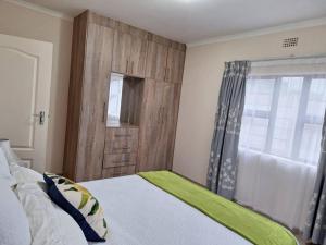 - une chambre avec un lit doté d'une porte en bois et d'une fenêtre dans l'établissement Valley Rest, à Mbabane