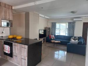 Il comprend une cuisine et un salon doté d'un canapé bleu. dans l'établissement Valley Rest, à Mbabane 4 autres photos