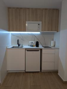 een witte keuken met een spoelbak en een magnetron bij Luna del este in Peñíscola