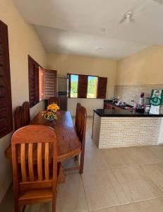 een keuken en eetkamer met een houten tafel en stoelen bij Casa da Duna Moitas-Icaraizinho de Amontada Ceará in Praia de Moitas