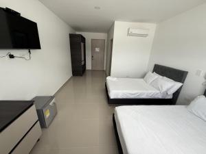 een kamer met 2 bedden en een flatscreen-tv bij Tierra Bendecida Hotel Boutique in Villavicencio +9 foto's